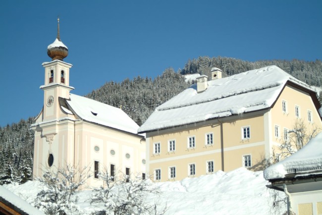 Pfarrkirche Flachau mit Pfarrhof im Winter